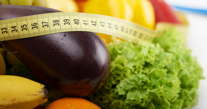 stock-photo-healthy-nutrition-concept-close-up-of-fresh-vegetables-and-fruits-with-measuring-tape-lying-on-333601613